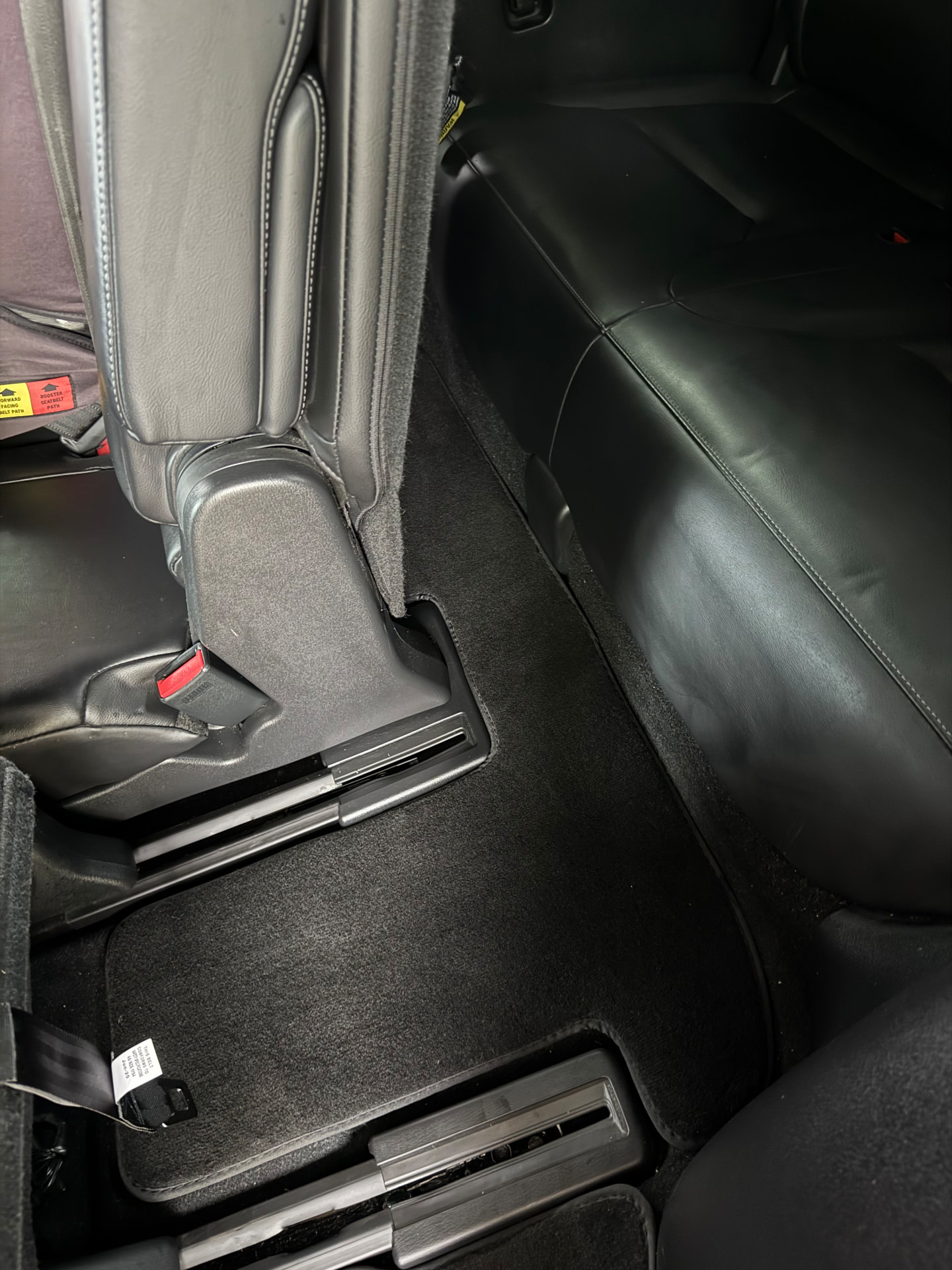 The same rear floor vacuumed spotless with a fresh floor mat after detailing