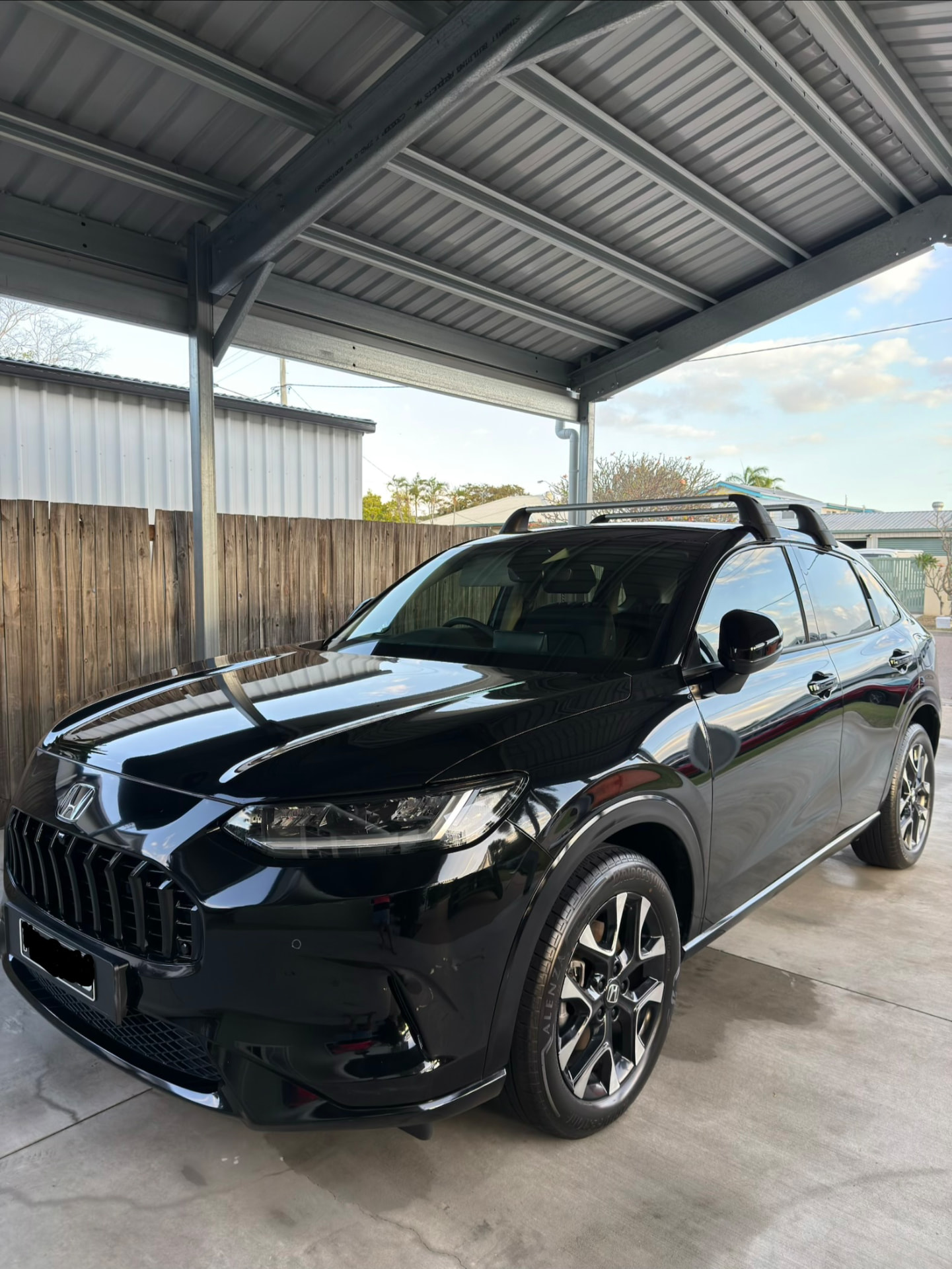 Glossy black SUV freshly detailed, parked in the shade